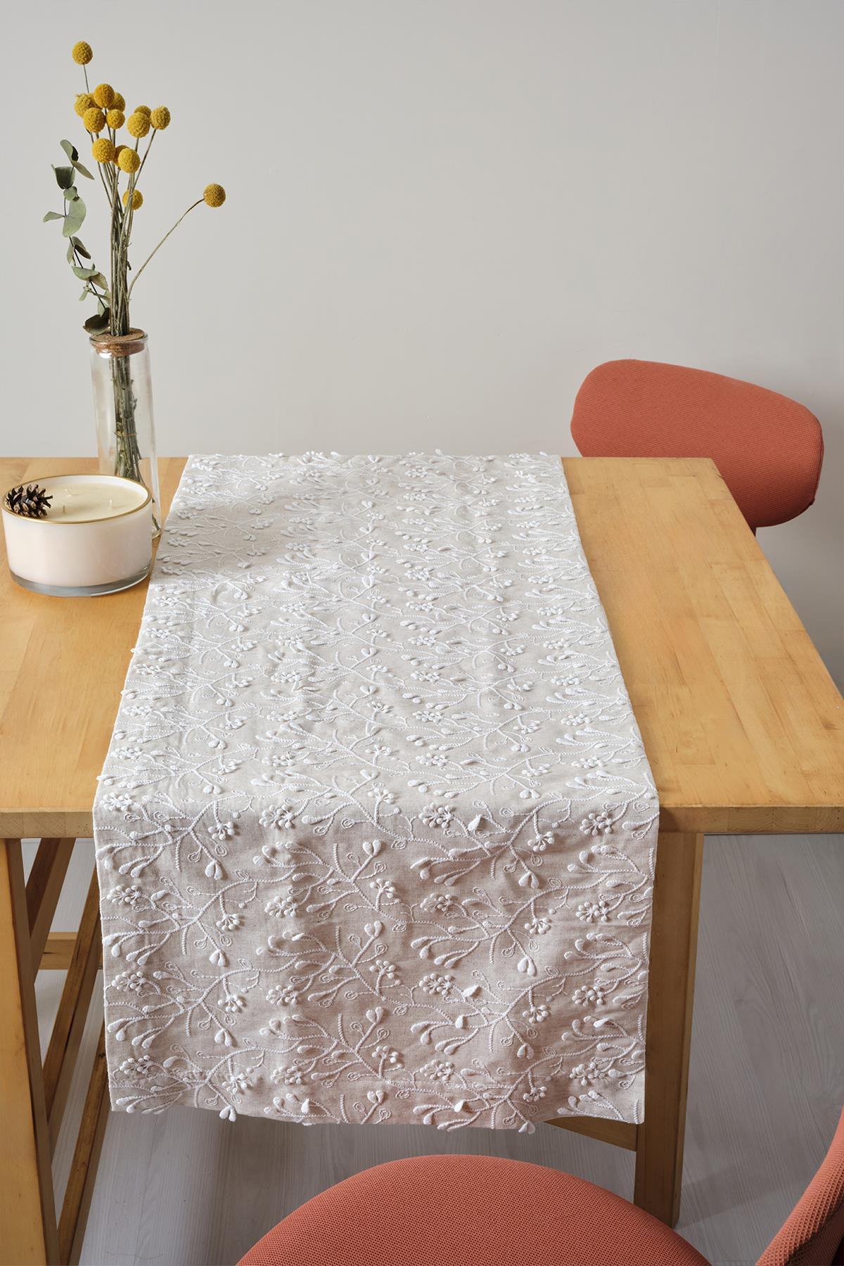 Tovaglia con ricami in pizzo, presentazione decorativa su tavolo in legno naturale