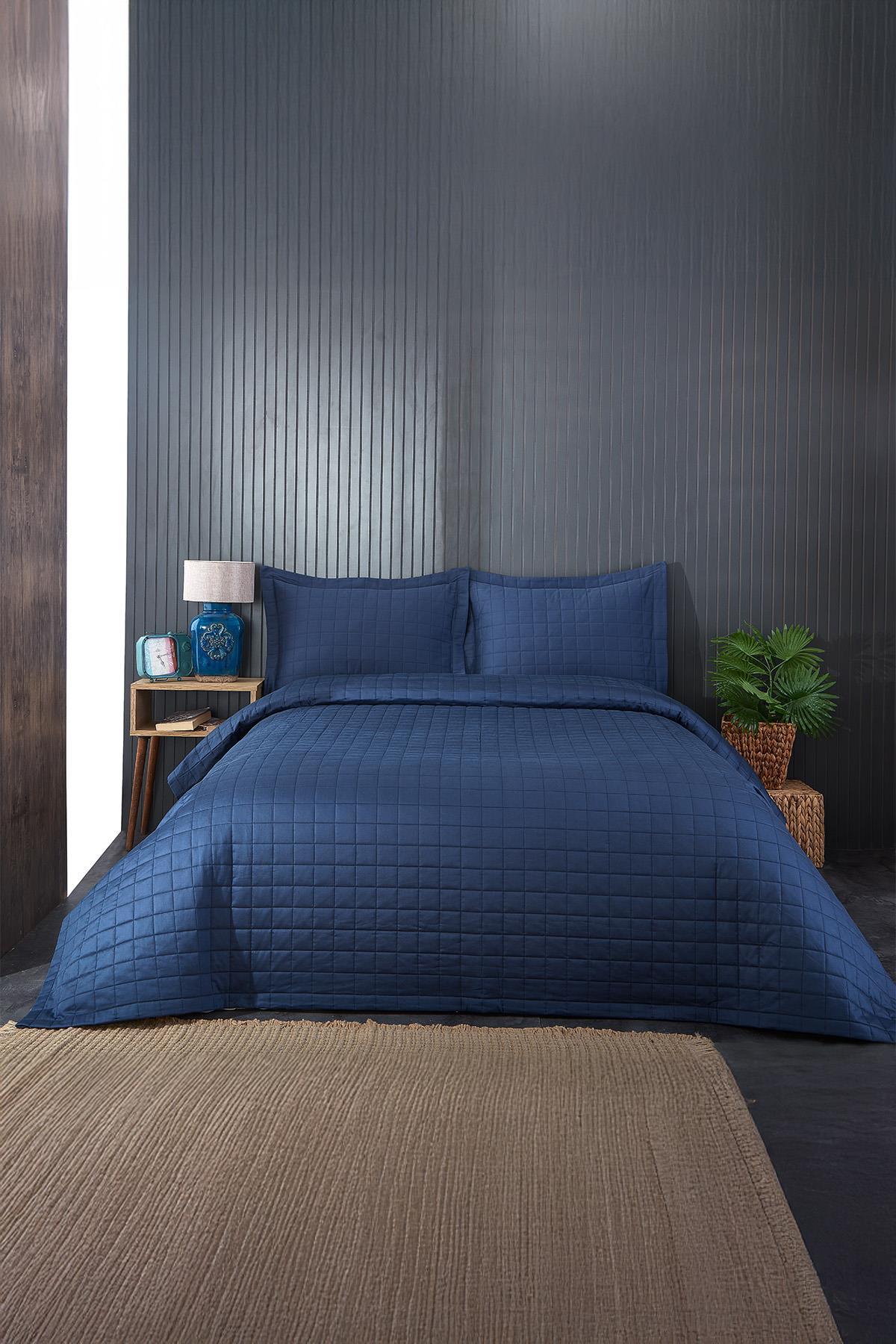 Copriletto matrimoniale trapuntato blu navy con set di federe in una camera da letto moderna