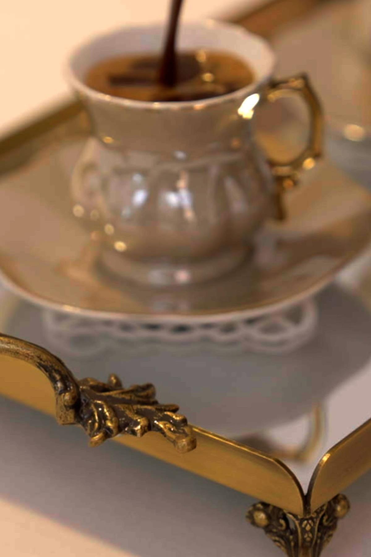 Caffè in una tazza di porcellana su un grande vassoio anticato, dettagli del vassoio con manici eleganti