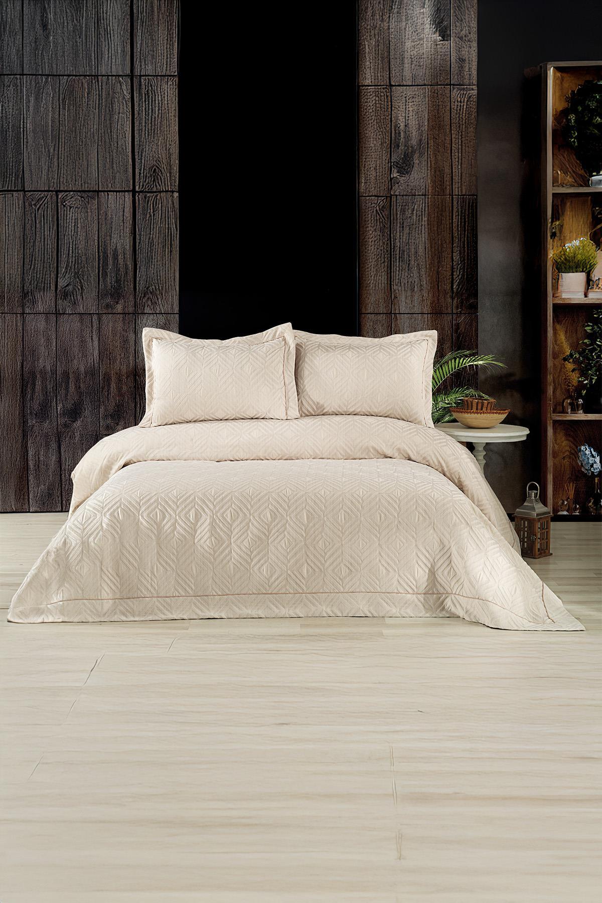 Copriletto matrimoniale jacquard con motivo geometrico beige e cuscini, in una camera da letto moderna.
