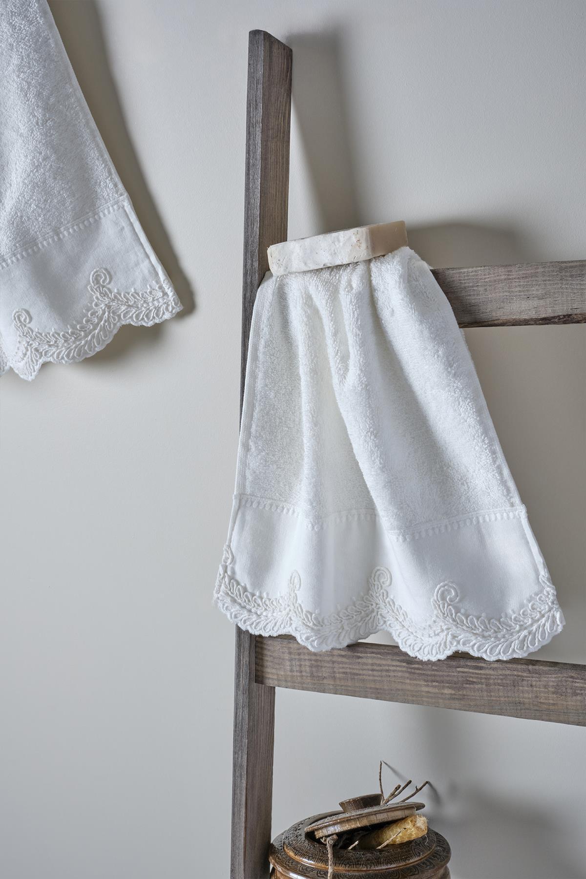 Asciugamano con ricami in pizzo bianco, presentazione decorativa su scala in legno