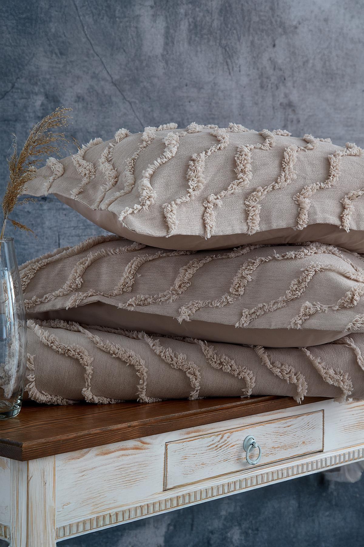 Copriletto singolo e cuscini decorativi color beige con texture effetto lino e motivo ondulato