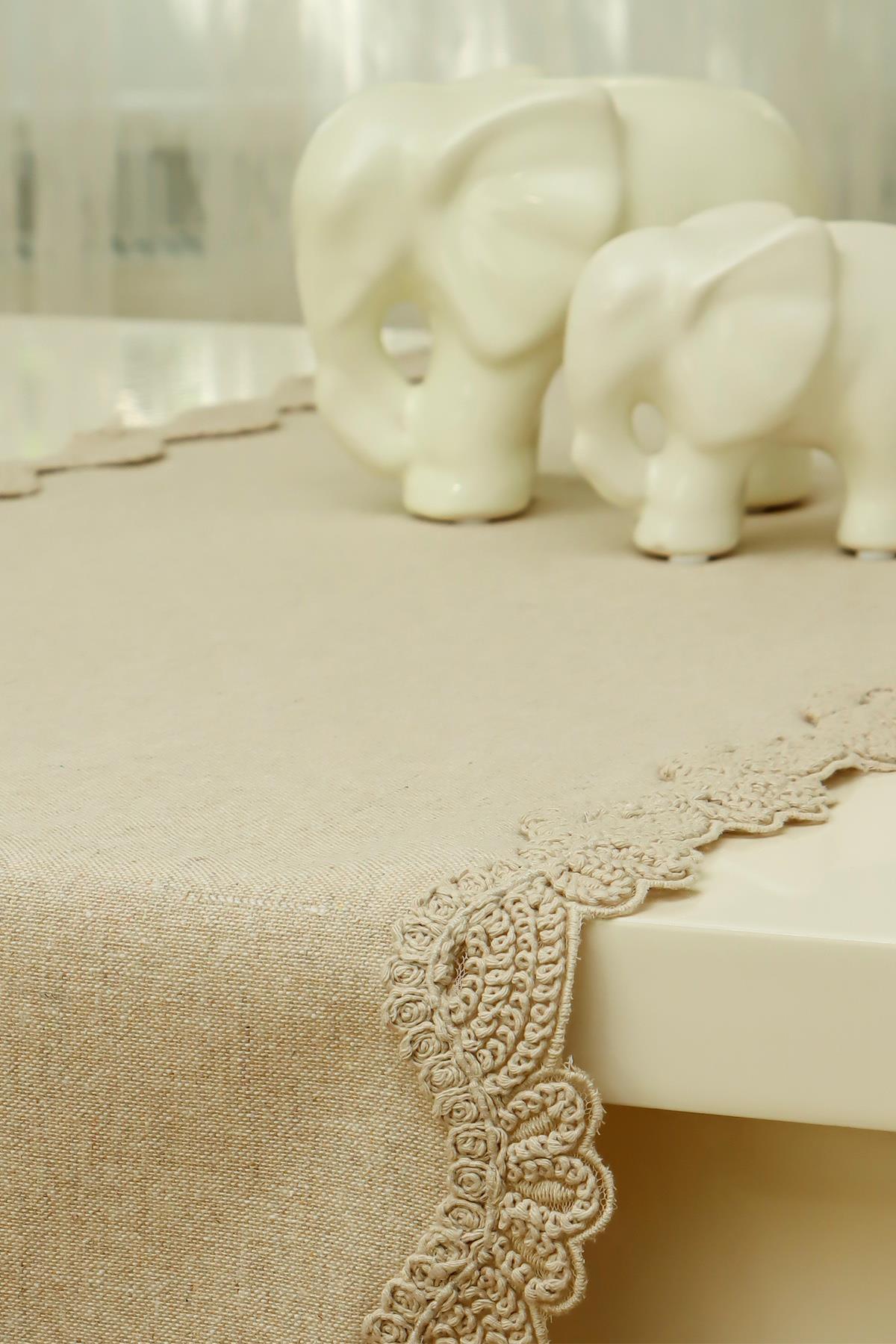 Tovaglia color crema con bordo in pizzo e decorazioni a forma di elefante in porcellana