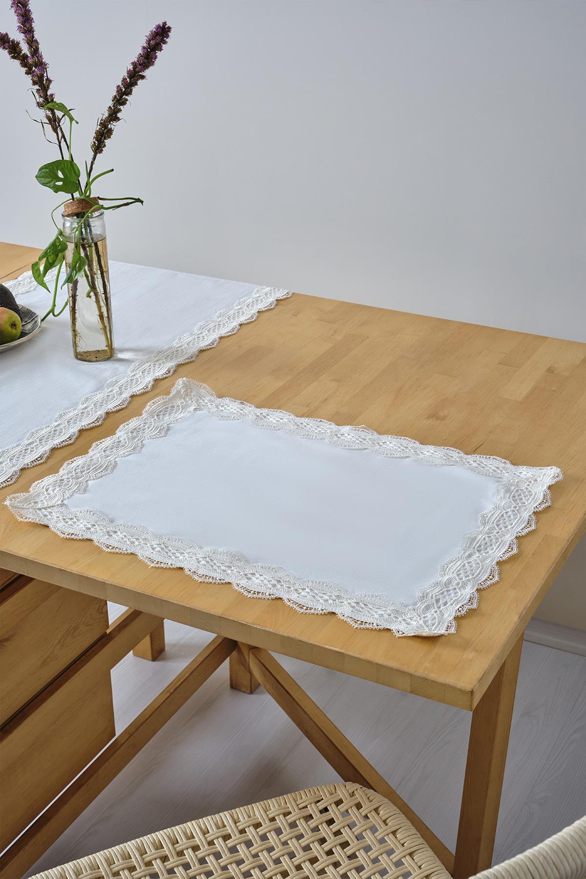 Tovaglietta americana bianca con bordo in pizzo su tavolo in legno, decorazione tavola elegante
