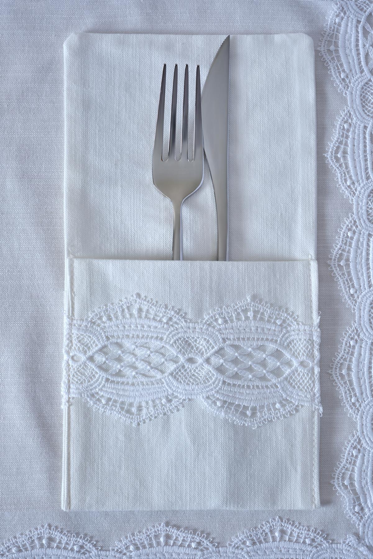 Forchetta e coltello su tovagliolo bianco con dettagli in pizzo, elegante presentazione della tavola