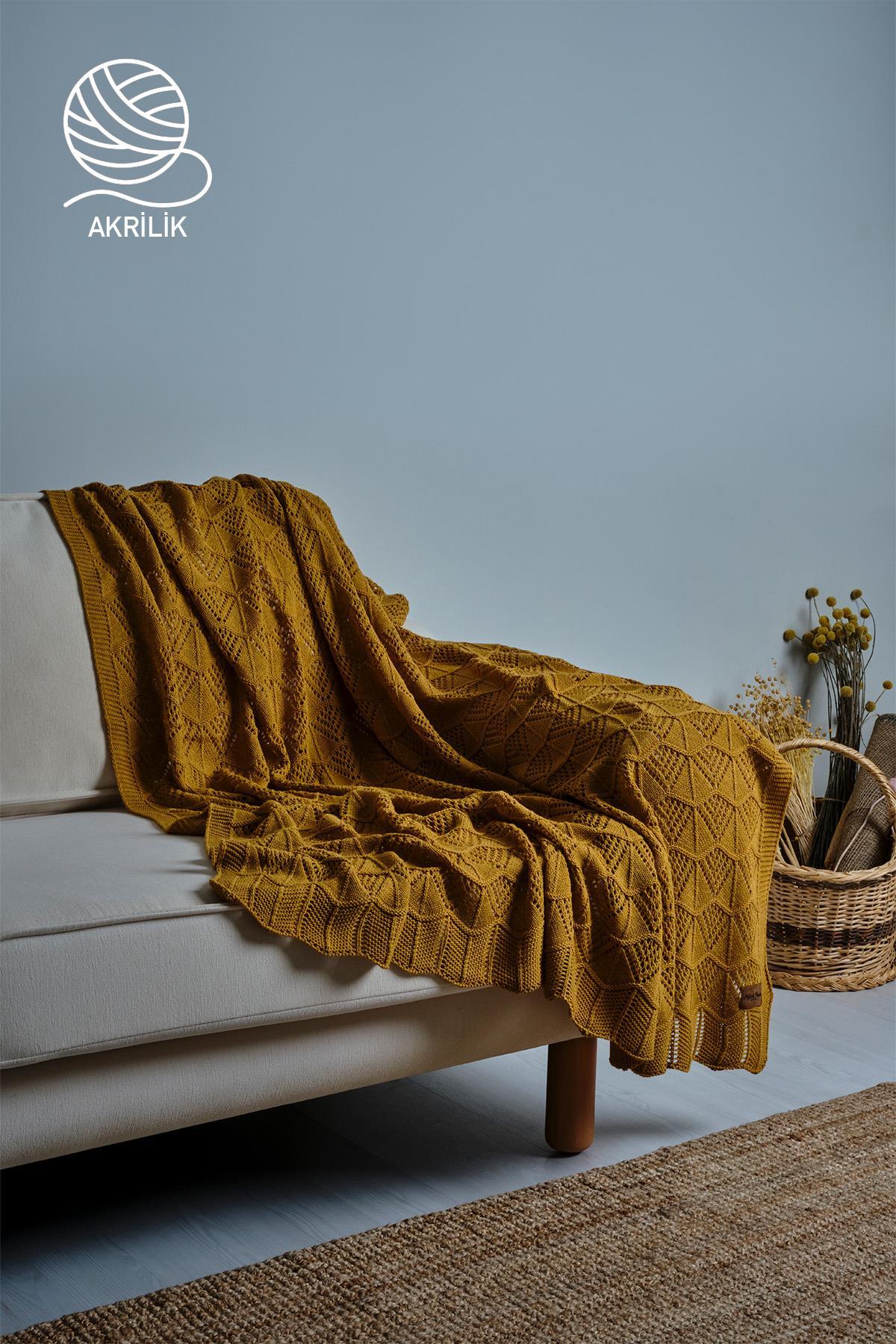 Coperta TV in acrilico a maglia grossa color giallo, disposta in modo decorativo su un divano