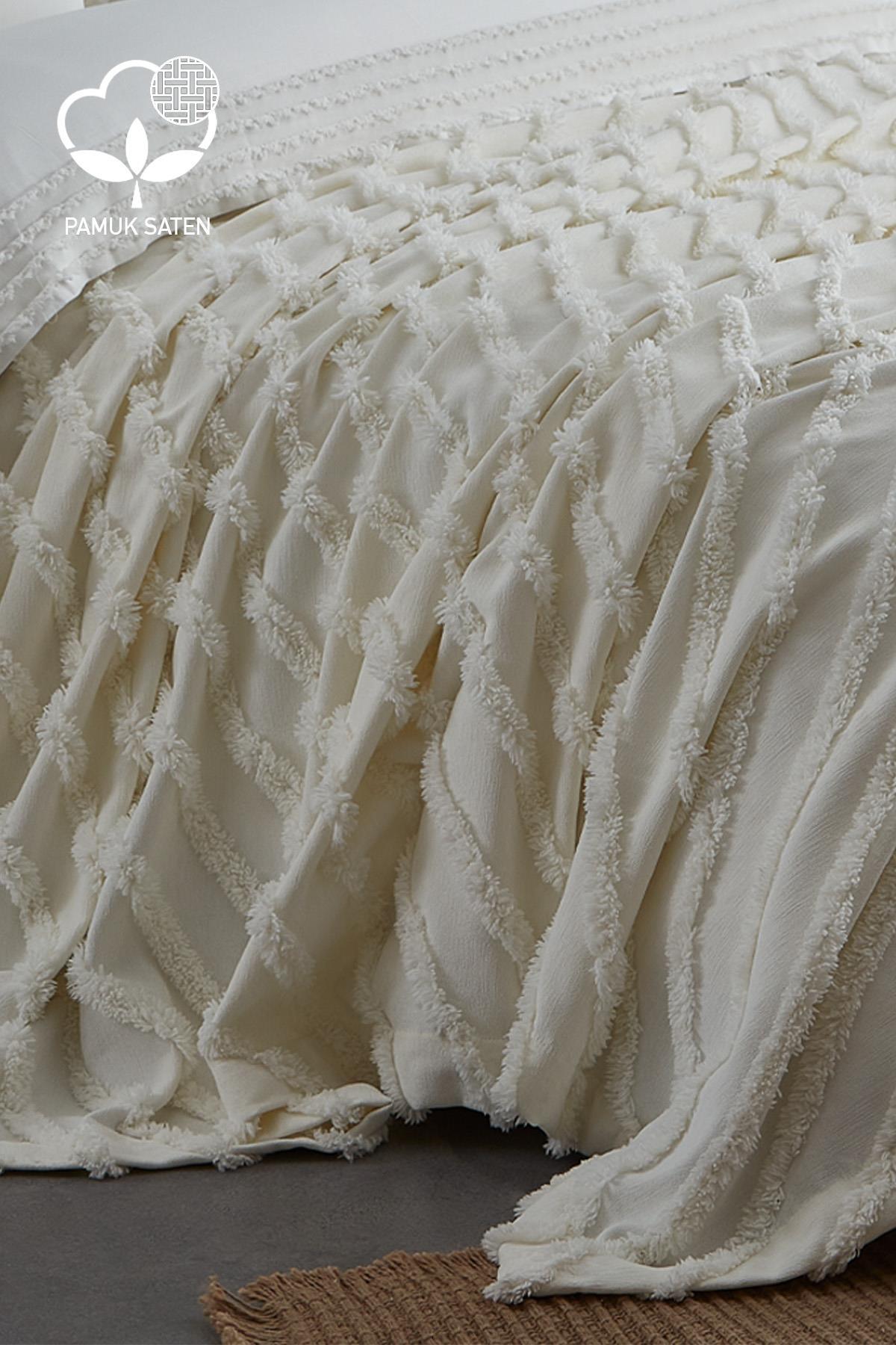 Set copripiumino e copriletto matrimoniale in raso di cotone color crema, con texture, steso sul letto