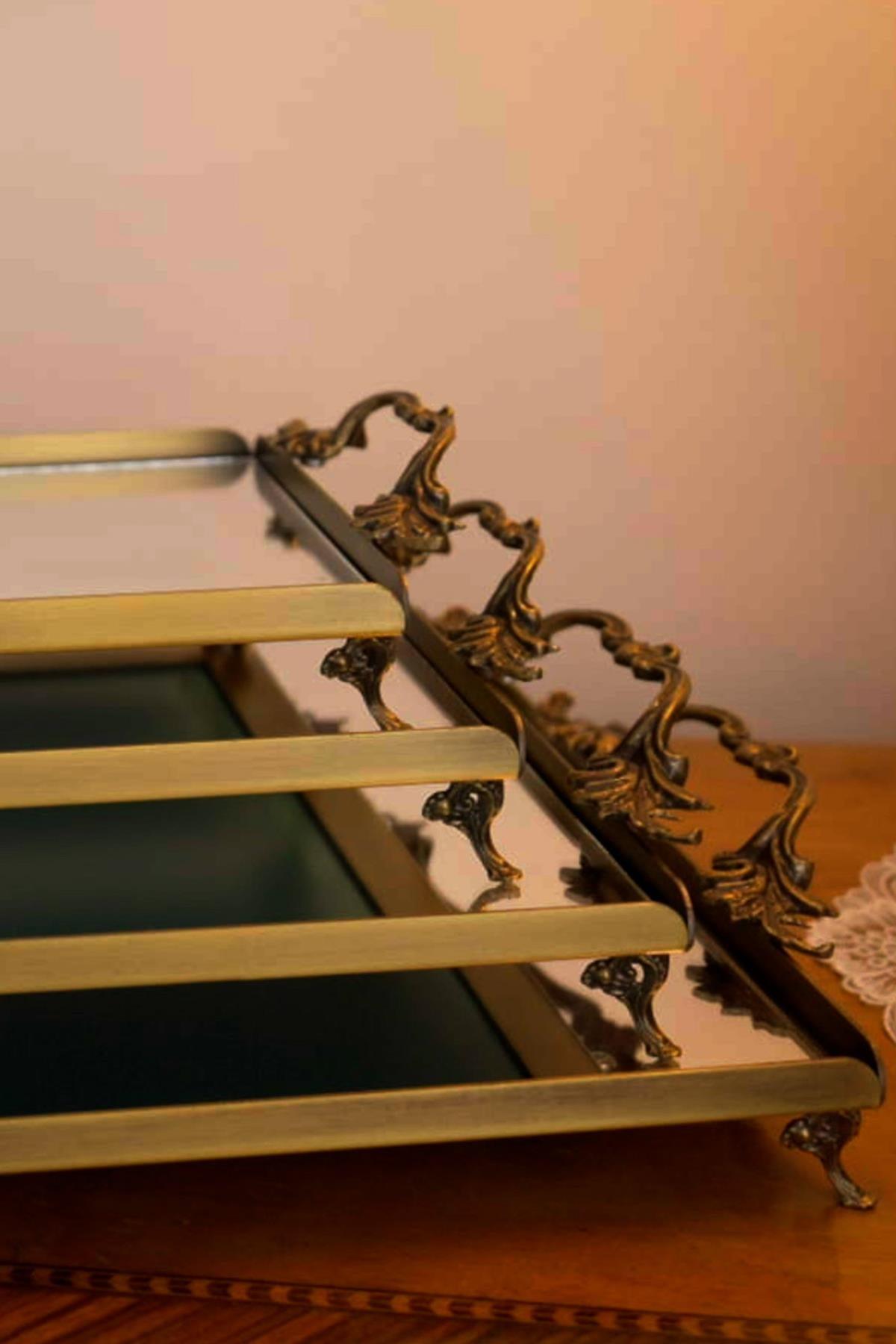 Mini vassoio in metallo dall'aspetto anticato con manici eleganti, superficie a specchio e piedini decorativi.