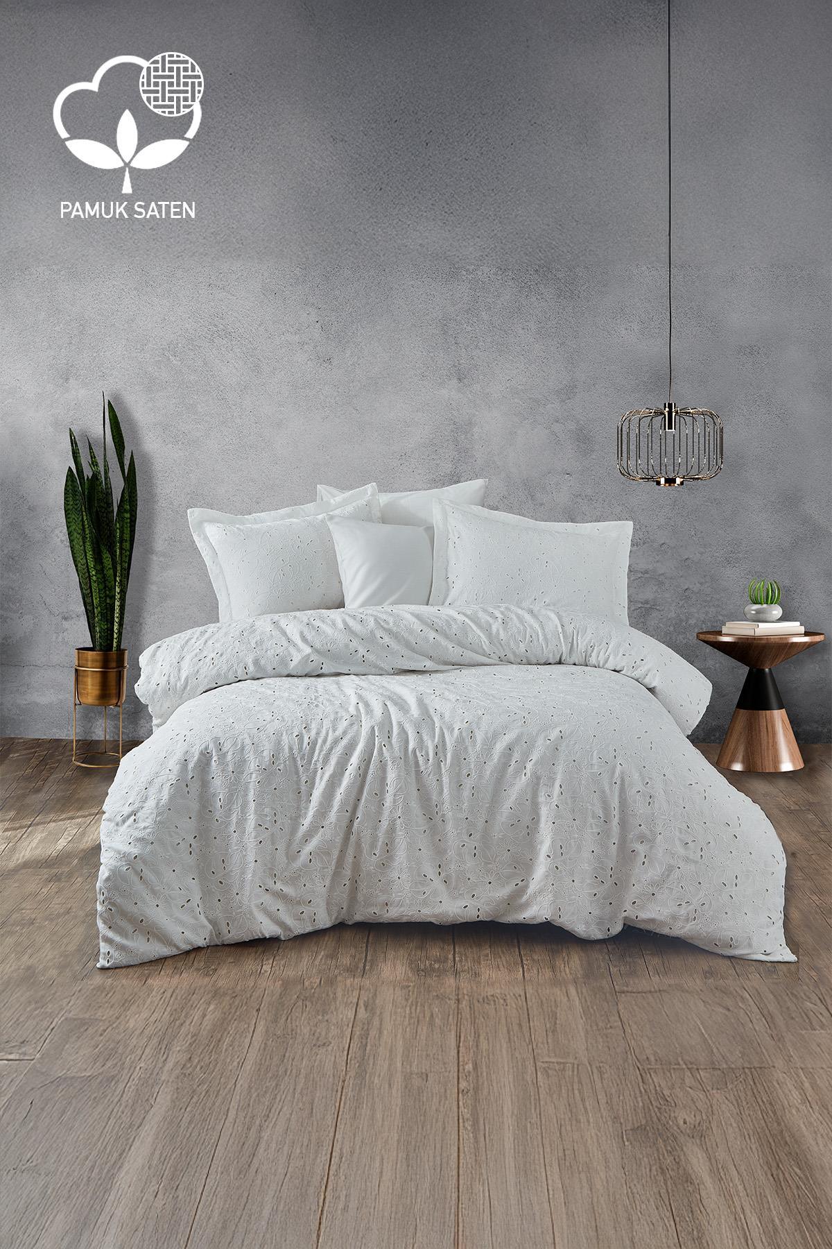 Set copripiumino matrimoniale in raso di cotone bianco con ricamo Nill, in una camera da letto moderna