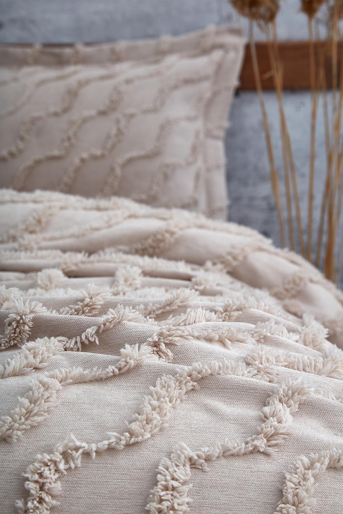 Copriletto singolo beige con texture in lino e dettagli a nappa, completo di federa