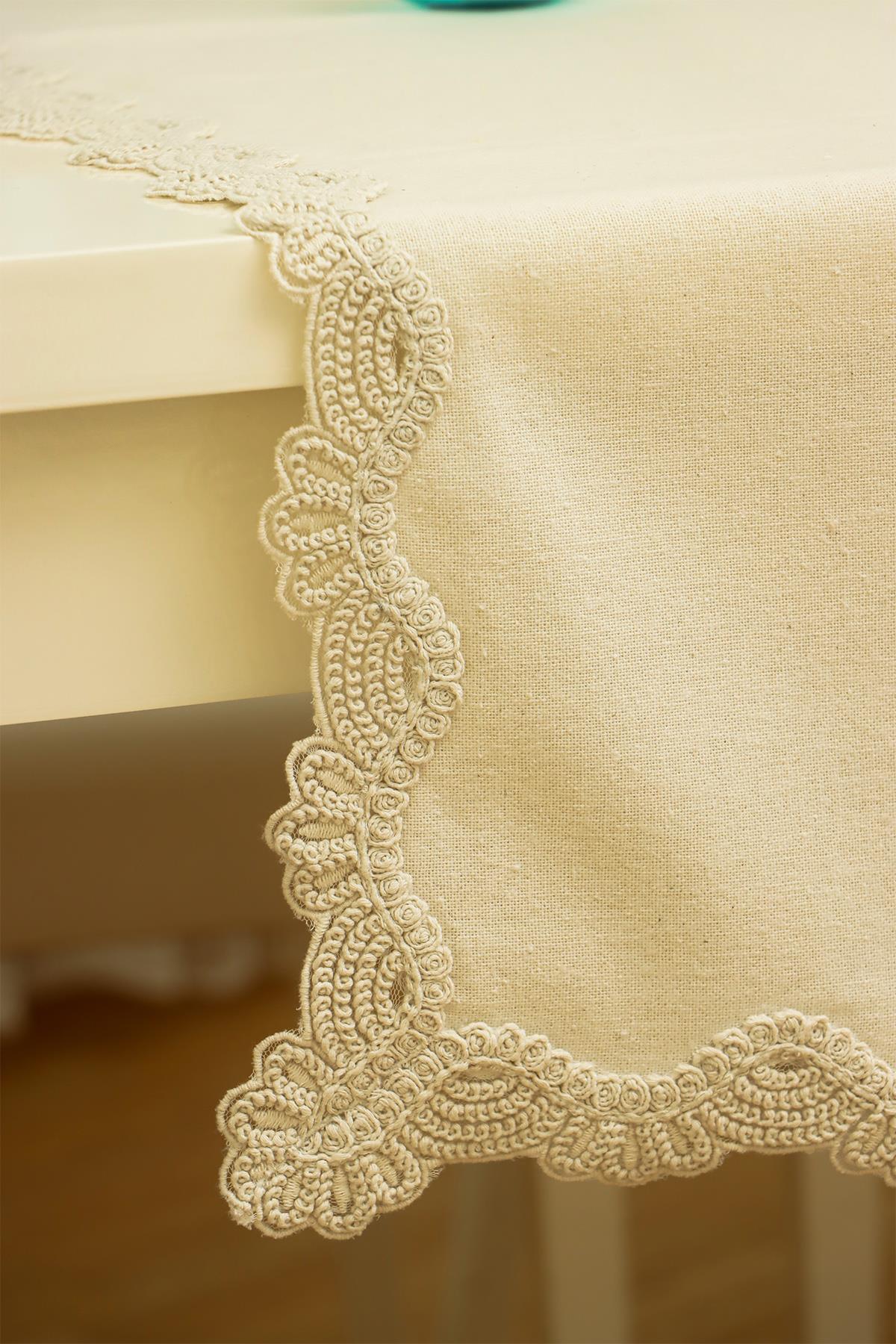 Tovaglia color crema con eleganti dettagli in pizzo sui bordi, decorazione moderna per la tavola.
