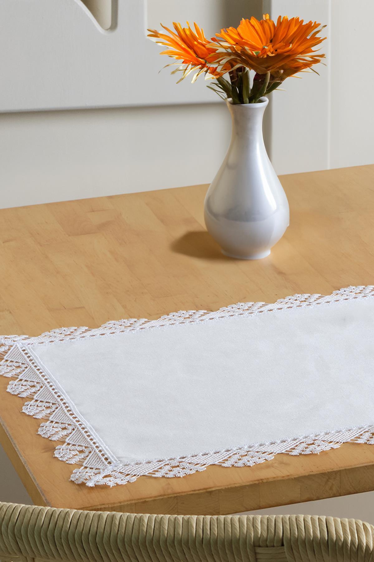 Runner da tavola bianco con bordo in pizzo, con vaso decorativo su tavolo in legno